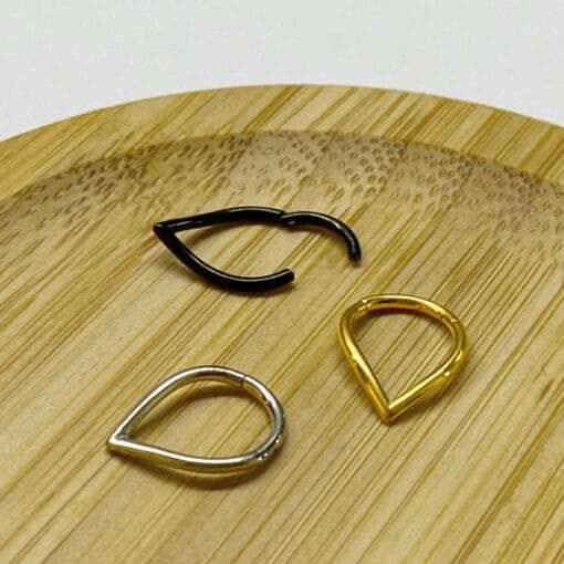 Clicker de acero quirúrgico color con forma de V para piercing de oreja y septum. Disponible con baño de oro y en color negro.