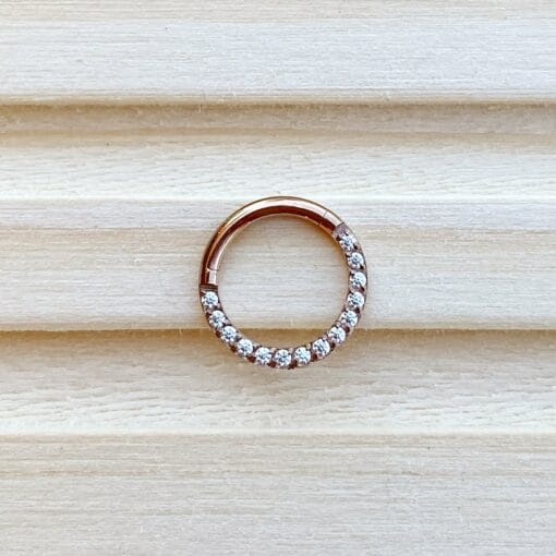 Clicker de titanio con baño de oro rosa y zirconias frontales