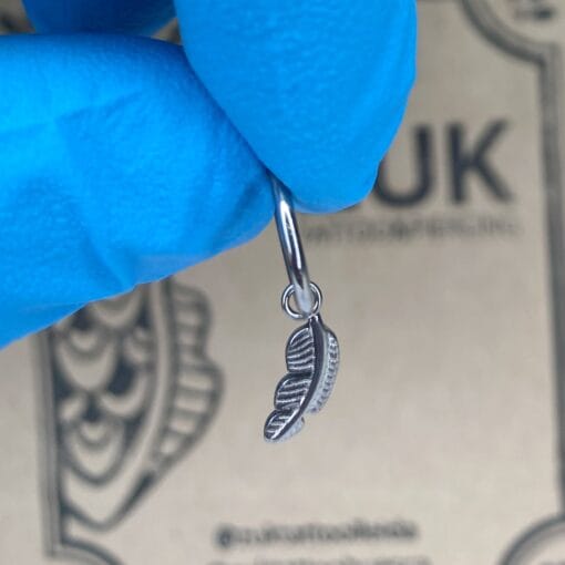 Charm de titanio con una pluma